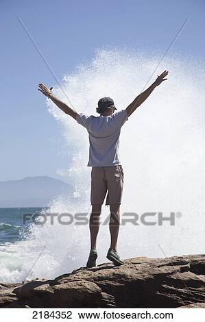 Stock Image - South Africa, Man Standing On Rocks; Mossel Bay. Fotosearch