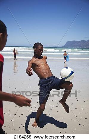 Stock Photo - South Africa, Muizenberg; Cape Town, Local Boys Playing Football On Beach. Fotosearch