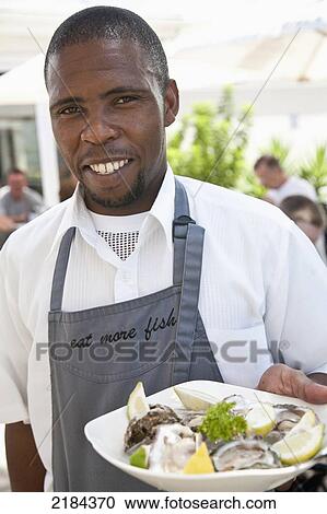 Stock Image - South Africa, Portrait Of Waiter At Protea Hotel Restaurant; Mossel Bay. Fotosearch