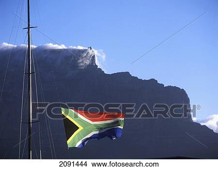 Picture - South African Flag Flying Above Victoria And Albert Waterfront With Cape Town And Table Mountain Behind, South Africa.. Fotosearch