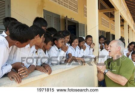 South East Asia, Cambodia, Siem Reap, A Group Of Young School Children Laugh While Tourist Teaches Them To Make Noises With Their Hands. View Large Photo Image Stock Photography - South East Asia, Cambodia, Siem Reap, A Group Of Young School Children Laugh While Tourist Teaches Them To Make Noises With Their Hands.. Fotosearch