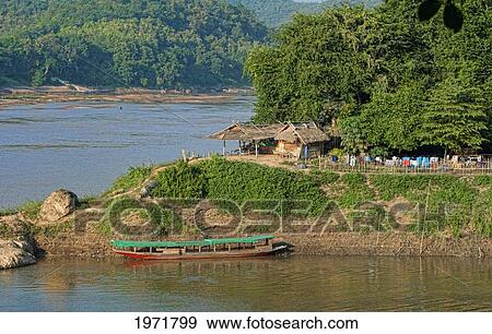 South East Asia, Laos, Luang Prabang, Small Home And Boat On The Mekong River. View Large Photo Image Stock Photo - South East Asia, Laos, Luang Prabang, Small Home And Boat On The Mekong River.. Fotosearch