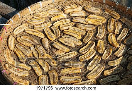 Stock Photograph - South East Asia, Laos, Luang Prabang, Locals Make Sun Dried Bananas To Sell In Marketplace.. Fotosearch