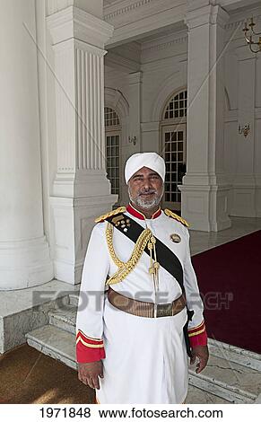 Stock Photo - South East Asia, Malaysia, Singapore, Portrait Of A Doorman At The Upscale Raffles Hotel And Resort.. Fotosearch