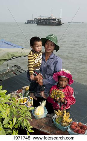 South East Asia, Vietnam, Ha Long Bay, Vietnamese Woman And Her Children Sell Fresh Fruit In Harbor. View Large Photo Image Stock Photo - South East Asia, Vietnam, Ha Long Bay, Vietnamese Woman And Her Children Sell Fresh Fruit In Harbor.. Fotosearch