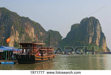 South East Asia, Vietnam, Ha Long Bay, Traditional Old Boats Arrive In Harbor With Tourists. View Large Photo Image Stock Photo - South East Asia, Vietnam, Ha Long Bay, Traditional Old Boats Arrive In Harbor With Tourists.. Fotosearch