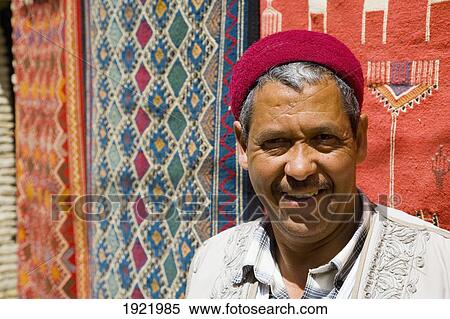 Stock Photography - Souvenir Shop Keeper By Carpets. Fotosearch