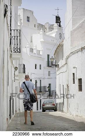 Stock Photograph - Spain, Andalucia, Costa De La Luz, Man Walking In Old Town; Vejer De La Frontera. Fotosearch