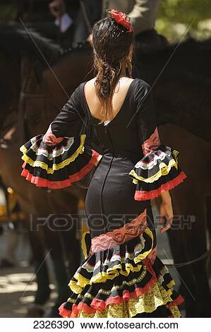 Stock Image - Spain, Andalusia, A woman dressed in a costume for the April Fair; Seville. Fotosearch