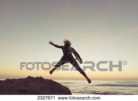 Spain, Andalusia, Cadiz, Costa de la Luz, Surfer jumping from rock; Tarifa View Large Photo Image Stock Image - Spain, Andalusia, Cadiz, Costa de la Luz, Surfer jumping from rock; Tarifa. Fotosearch