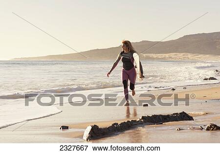 Stock Photo - Spain, Andalusia, Cadiz, Costa de la Luz, Surfer on beach; Tarifa. Fotosearch