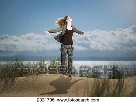 Spain, Andalusia, Cadiz, Teenage Girl Standing On Sand Dune With Arms Outstretched And Looking Up; Tarifa View Large Photo Image Stock Photograph - Spain, Andalusia, Cadiz, Teenage Girl Standing On Sand Dune With Arms Outstretched And Looking Up; Tarifa. Fotosearch