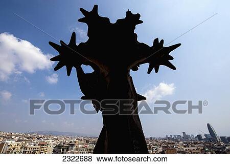 Stock Photo - Spain, Backlit statue in front of cityscape; Barcelona. Fotosearch