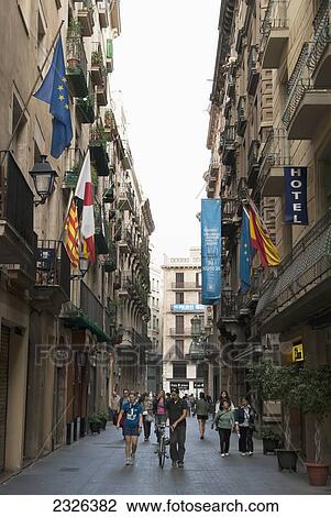 Stock Image - Spain, Catalonia, near La Rambla; Barcelona, Pedestrians in a narrow street in Barri Gothic. Fotosearch