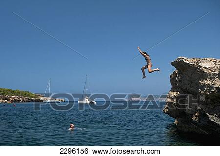 Spain, Girl jumping off small cliff on La Basse beach; Ibiza View Large Photo Image Stock Photograph - Spain, Girl jumping off small cliff on La Basse beach; Ibiza. Fotosearch