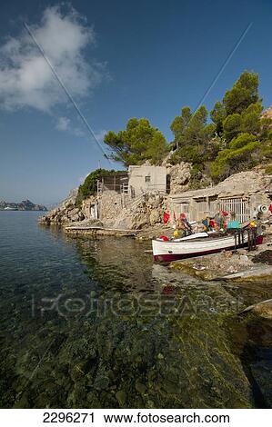 Stock Image - Spain, Ibiza, Fishermen preparing their boat; Cala d'Hort beach. Fotosearch