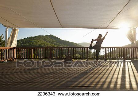 Stock Image - Spain, Ibiza, Lady doing yoga at Ibiza Yoga; Benirras. Fotosearch