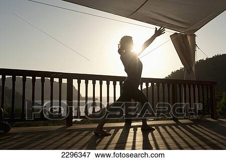 Stock Photo - Spain, Ibiza, Lady doing yoga at Ibiza Yoga; Benirras. Fotosearch
