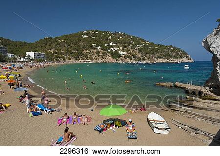 Stock Photograph - Spain, Ibiza, People relaxing at beach; Cala de San Vicente beach. Fotosearch