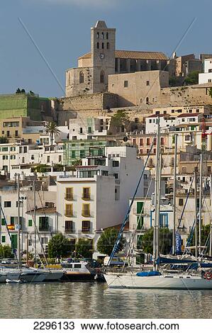 Stock Image - Spain, Looking across harbor to Ibiza Town; Ibiza. Fotosearch
