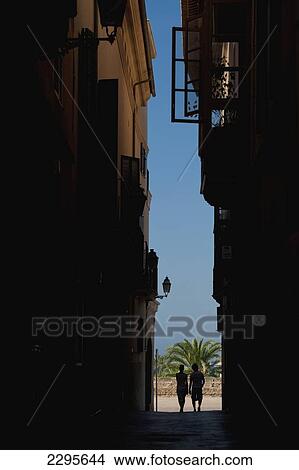 Spain, Majorca, Couple walking along narrow alley; Palma View Large Photo Image Picture - Spain, Majorca, Couple walking along narrow alley; Palma. Fotosearch