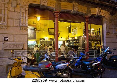 Stock Photo - Spain, Majorca, Scooters outside Tapas bar in evening; Palma. Fotosearch