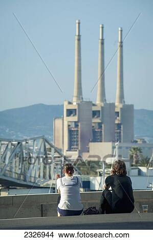 Picture - Spain, Parc del Forum; Barcelona, Festival goers enjoying the sun and views of chimneys at Primavera Sound music festival. Fotosearch
