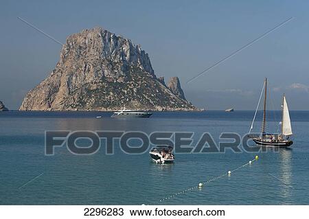 Spain, People on boats off Cala d'Hort beach with Es Vedra Island behind; Ibiza View Large Photo Image Stock Image - Spain, People on boats off Cala d'Hort beach with Es Vedra Island behind; Ibiza. Fotosearch