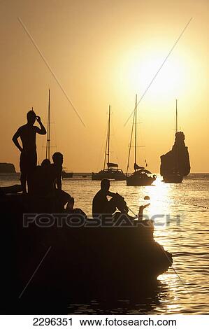 Spain, People watching sunset on rocks beside Benirras beach; Ibiza View Large Photo Image Stock Image - Spain, People watching sunset on rocks beside Benirras beach; Ibiza. Fotosearch