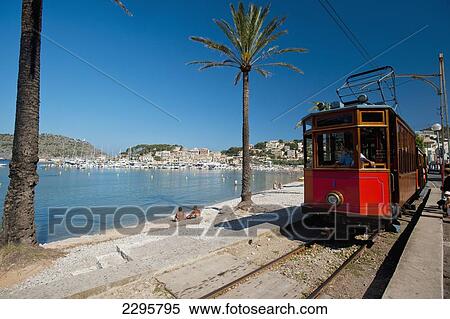 Stock Photography - Spain, Port Soller; Majorca, Port Soller to Soller tram going past beach. Fotosearch