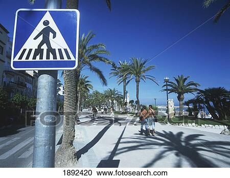 Stock Image - Spain, Promenade With Palm Trees And Road Sign; Sitges. Fotosearch