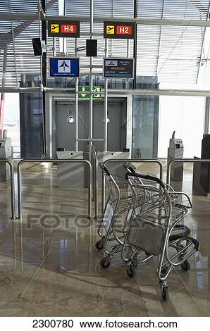 Stock Image - Spain, Trolleys At Airport Gate; Madrid. Fotosearch