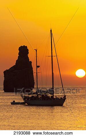 Spain, Yachts and strange shaped rock off Benirras beach at dusk; Ibiza View Large Photo Image Stock Photo - Spain, Yachts and strange shaped rock off Benirras beach at dusk; Ibiza. Fotosearch
