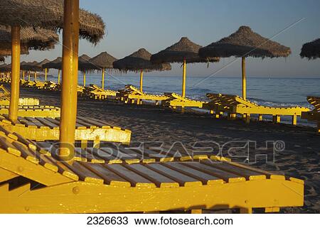 Spain, Yellow beach chairs and straw sun umbrellas; Malaga View Large Photo Image Stock Image - Spain, Yellow beach chairs and straw sun umbrellas; Malaga. Fotosearch