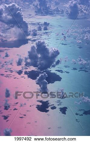 Stock Image - Special Effect Pink/Blue Sky, White Puffy Cumulus Clouds, View From Above A35D. Fotosearch
