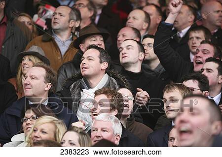 Stock Image - Spectators at Cheltenham horse racing Festival; Cheltenham, Gloucestershire, England. Fotosearch