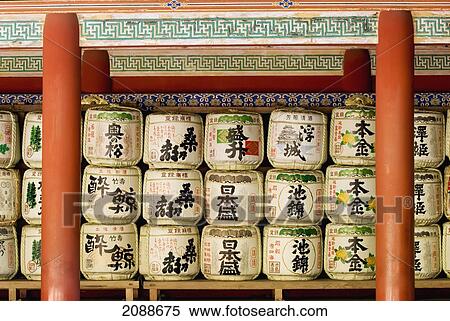 Stock Photography - Stacks Of Bales Of Offers To The Gods Under Roof Of A Red Shrine; Nikko Japan. Fotosearch