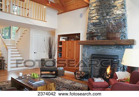 Stock Image - Staircase To Living Room Of Home With Fireplace; Mayne Island, British Columbia, Canada. Fotosearch