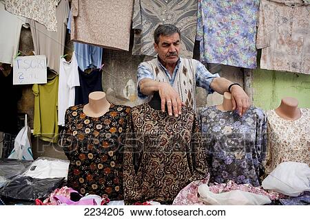 Stock Photography - Stall holder selling womens shirts at Carsamba Pazari, the Wednesday Market in Fatih is one of Istanbul's oldest and most colourful market places, which is located around a network of streets surrounding the Fatih Mosque in Istanbul, Turkey. Photo. Fotosearch