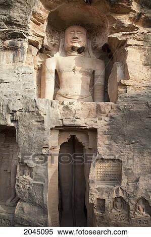 Stock Photography - Standing Jain Sculpture Of Adinath Carved In To The Cliff On The Southern Approach To The Fort, Gwalior, Madhya Pradesh, India. Fotosearch