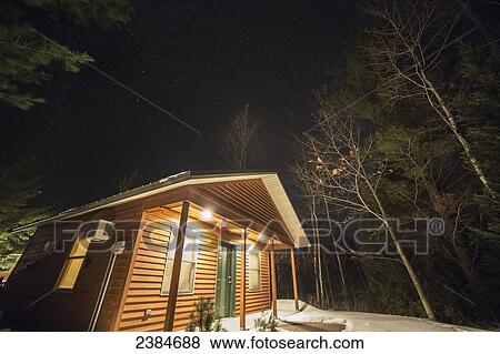 Stock Photo - Stars in the night sky over a cabin; Bayfield, Wisconsin, United States of America. Fotosearch