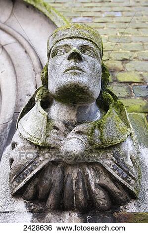 Stock Photograph - Statue covered in moss at Winchester College; Winchester, Hampshire, England. Fotosearch