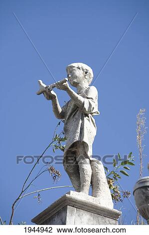 Stock Image - Statue of a boy atop a mausoleum at the Cementerio de la Recoleta, Buenos Aires, Capital Federal, Argentina. Fotosearch