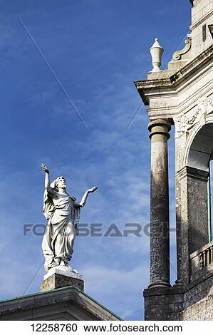 Statue of bearded man raising arms to the sky with church bell tower and blue sky; Athlone, County Westmeath, Ireland View Large Photo Image Stock Image - Statue of bearded man raising arms to the sky with church bell tower and blue sky; Athlone, County Westmeath, Ireland. Fotosearch