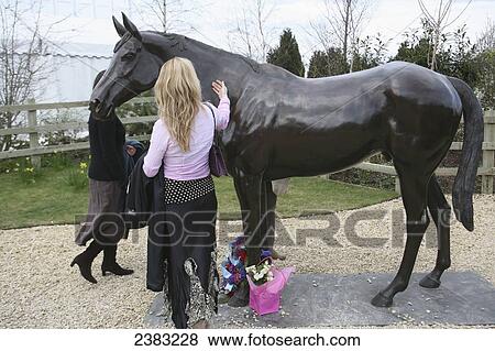 Stock Photo - Statue of Best Mate, one of the wonder horses who won three gold cups at Cheltenham horse racing festival on Gold Cup day, Prestbury; Cheltenham, Gloucestershire, England. Fotosearch