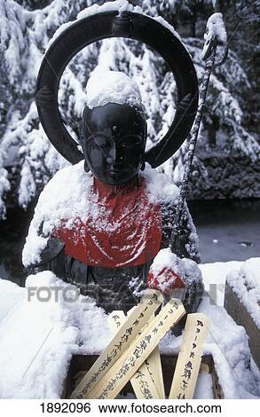 Stock Photograph - Statue Of Buddha Covered With Snow. Fotosearch