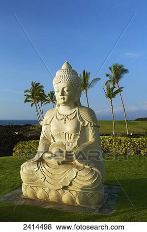 Stock Photo - Statue of Buddha with a view of palm trees and ocean in the background; Kauai, Hawaii, United States of America. Fotosearch