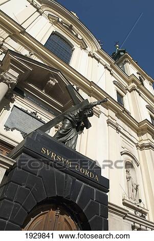 Stock Image - Statue of Christ bearing his cross in front of the baroque-styled Holy Cross church on the Royal Route, Krakowskie Przedmiescie, Poland. Fotosearch