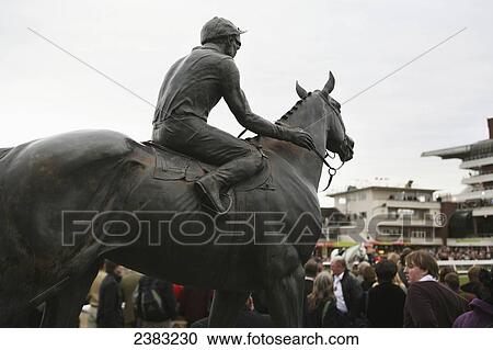 Stock Image - Statue of Dawn Run, a famous horse to run at Cheltenham overlooks the Parade Ring, Cheltenham Race course, Prestbury; Cheltenham, Gloucestershire, England. Fotosearch