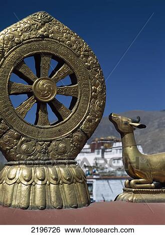 Stock Photograph - Statues Of Deer And Dharma Wheel On Top Of The Jokhang Temple With The Poata Palace In The Background, Lhasa, Tibet.. Fotosearch